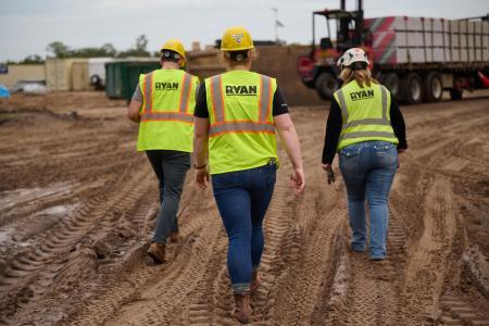 Ryan team members wearing their PPE gear walk through an active jobsite.